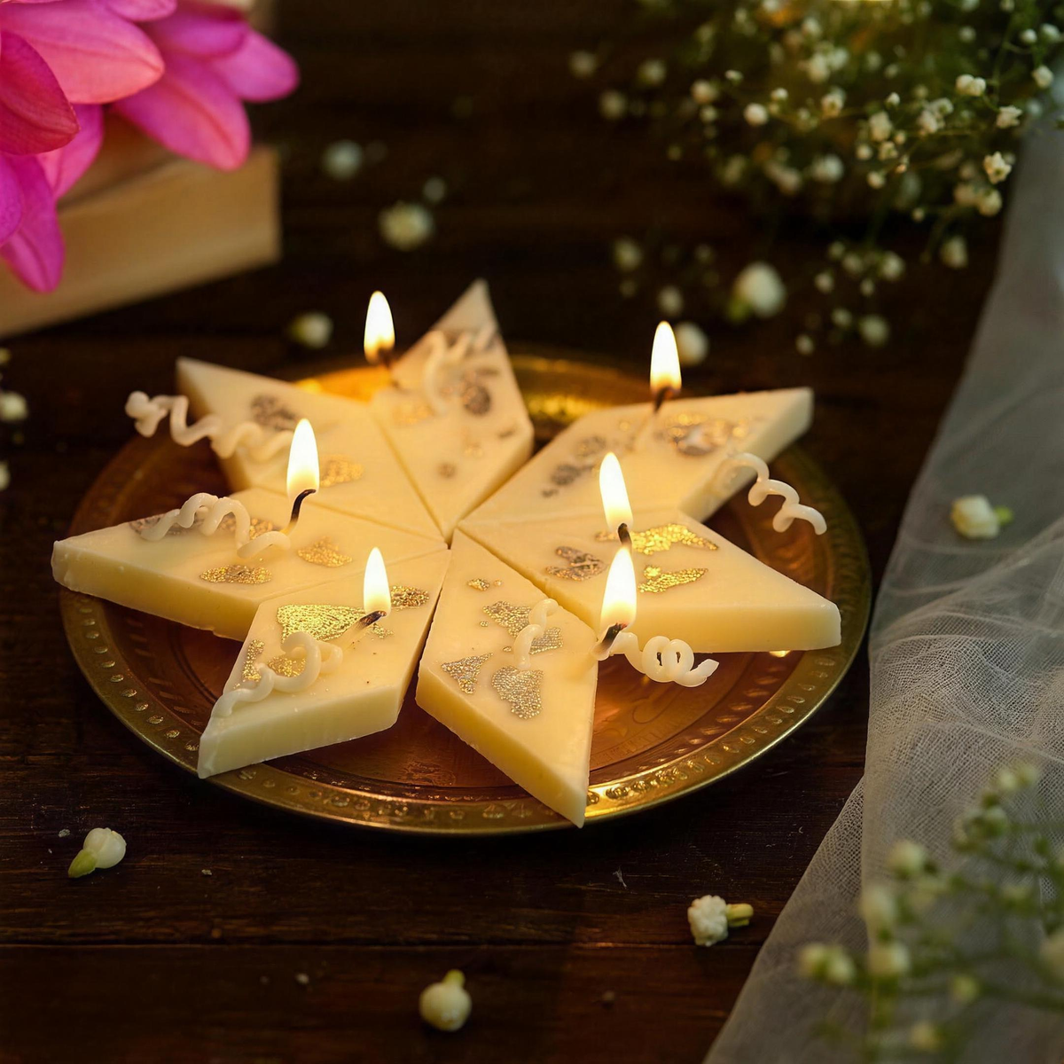 Kaju katli shaped candles on a brass plate